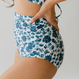 Hand on hip model posing in two-piece floral swimsuit